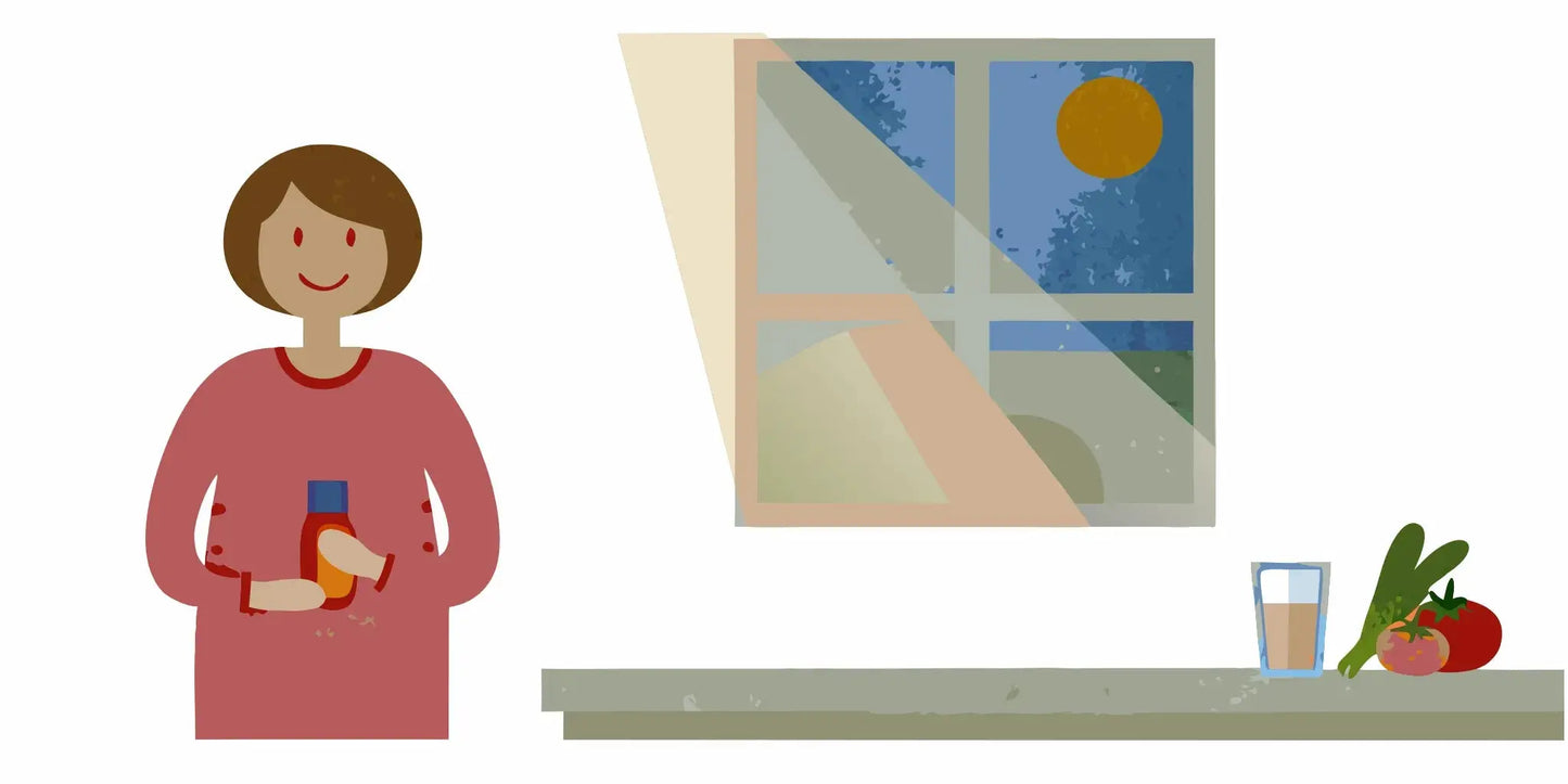 A woman preparing to take a digestive enzyme supplement before a meal in her kitchen.